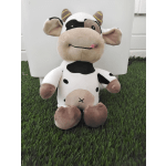 Plush cow toy sitting on artificial grass