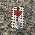 Heart-shaped gift card with a silver heart charm on a polka dot backing