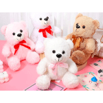 Four plush teddy bears with ribbon bows on a pink surface