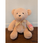 Peach plush teddy bear with a ribbon bow