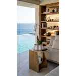 White orchid in a white ceramic pot on a side table by the sea.