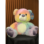 Rainbow plush teddy bear with glittery paws and a tag