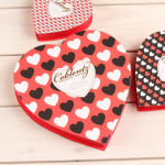 Heart-shaped chocolate boxes with red, black, and white heart patterns