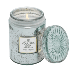 Lit scented candle in a glass jar with a decorative lid