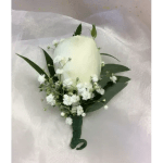 White rose boutonniere with baby's breath and dark green leaves