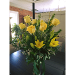 Yellow roses and lilies arranged in a tall glass vase