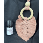 Macrame wall hanging and a small essential oil bottle on dark fabric