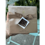 Box of assorted chocolates with a brown ribbon and gift tag