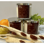 Three scented candles with citrus and dried botanicals arranged around them.