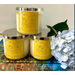 Three candles beside a pale blue hydrangea cluster