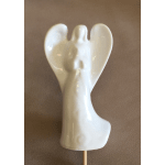 White ceramic angel figurine on a stick against a plain background