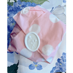 Pink polka-dot wrapped gift with a round white label