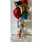 Birthday balloons with a teddy bear sitting below them