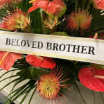 Tropical floral tribute with a "Beloved Brother" ribbon
