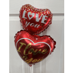 Two red heart-shaped balloons with love messages