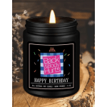 Black jar candle with a lit flame and birthday label