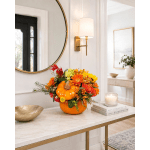 Pumpkin centerpiece with orange and yellow flowers