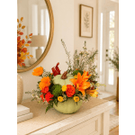 Pumpkin-shaped floral arrangement with orange and red blooms in a vase