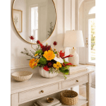 Colorful floral arrangement in a white pumpkin vase on a console table