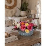 Pink and yellow roses in a blue ceramic bowl with small daisy accents