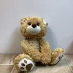 Plush teddy bear sitting on a tiled floor