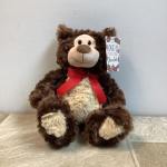 Plush brown teddy bear with a red ribbon and hanging gift tag