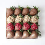 Box of chocolate-covered strawberries with assorted toppings