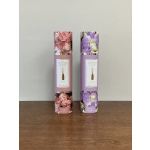 Two floral reed diffuser tubes on a wooden surface