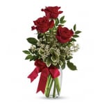 Red roses in a clear glass vase with a red ribbon