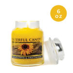 Yellow candle jar labeled sunflower and driftwood, with lid beside it