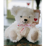 White teddy bear with a heart ribbon and gift tag