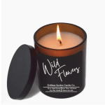 Lit candle in a black glass jar with a lid beside it