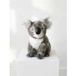Plush koala toy sitting on a white pedestal