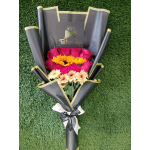 Bouquet of pink roses and yellow daisies wrapped in black paper