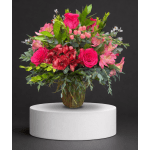 Pink roses and mixed blooms arranged in a glass vase