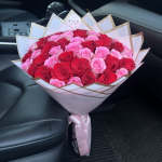 Large bouquet of pink and red roses wrapped in white paper