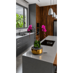Potted orchids with bright pink blooms in a gold container on a kitchen island.