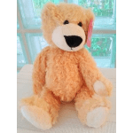 Plush teddy bear with tan fur and white paws sitting upright