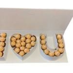 Heart and letter-shaped boxes filled with gold-wrapped chocolates
