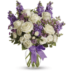 White roses and purple flowers in a glass vase with a purple ribbon