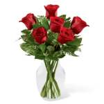 Six red roses arranged in a clear glass vase