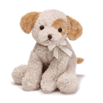 Small cream and tan plush puppy with a ribbon bow around its neck, sitting upright.