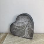 Heart-shaped memorial sign with a tree and remembrance text