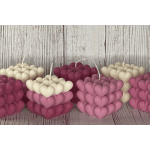 Heart-shaped layered candles in pink, magenta, and cream