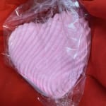 Pink heart-shaped soap in clear plastic wrapping