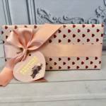 Heart-patterned gift box tied with a pink satin ribbon and tag