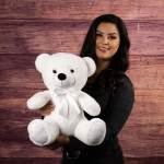 Woman holding a large white teddy bear with a ribbon