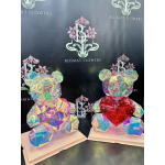 Two iridescent teddy bear figures with heart accents on display bases