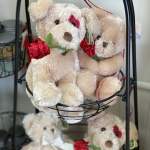 Plush teddy bears with red ribbon roses in a wire basket