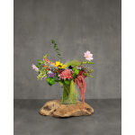 Mixed bouquet in a clear glass vase on a wooden slab